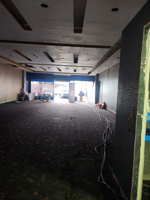 Bathroom with blue walls, utility sink, exposed plumbing inside retail space at La Gran Estación Panama