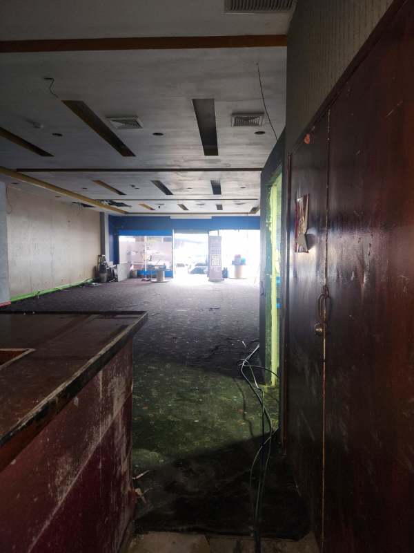 Open space with ceiling panels, glass storefront entrance at La Gran Estación San Miguelito Panama