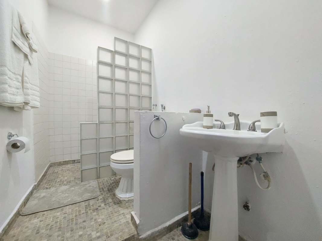 Minimalist bathroom with glass walk-in shower, pedestal sink, modern tiling Casco Viejo Panama