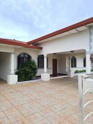 Spacious living room with tile flooring, sofa set, ceiling fan and red curtains in house at La Fontana Residences David Panama