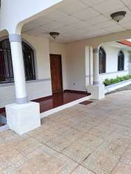 Covered entry porch with arched windows, columns and ceramic tile in La Fontana Residences house David Panama