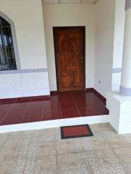 Traditional house entrance with wooden door, tiled porch and column at La Fontana Residences David Panama