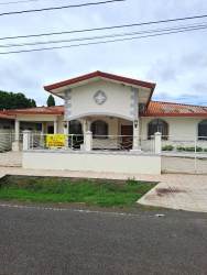 Street view Mediterranean house with gated fence, red tile roof, decorative columns in La Fontana Residences David Panama