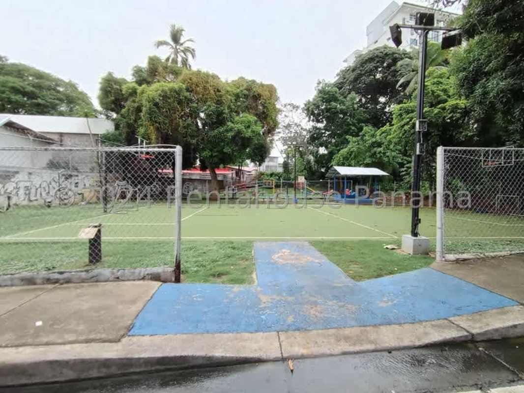 Urban outdoor sports court with shaded benches and city views near Carrasquilla lot lease