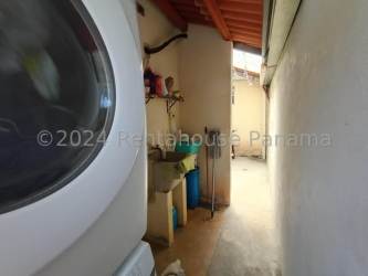 Small kitchen with wood cabinets, tile backsplash, fridge, microwave and gas stove in La Chorrera house