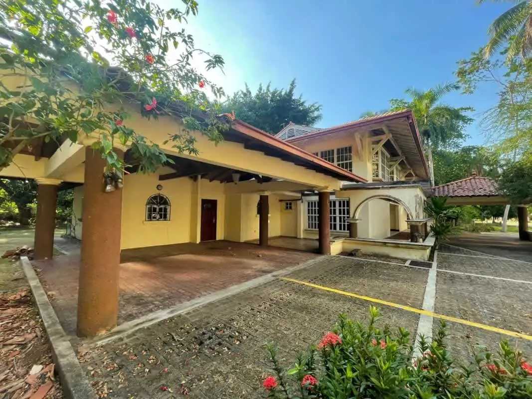 Two-story Mediterranean-style house with arch windows, covered carport and tile roof in Amador Panama