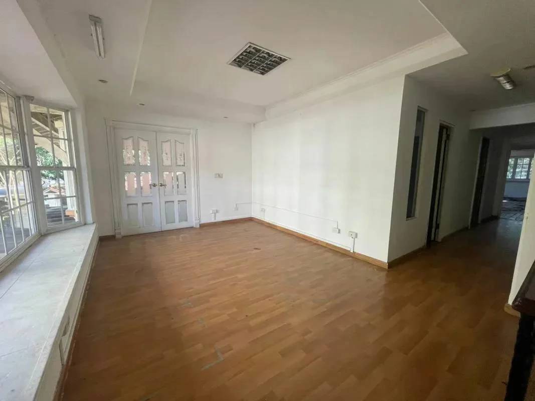 Spacious living room with large bay window, wooden flooring and double French doors in Mediterranean house Amador Panama