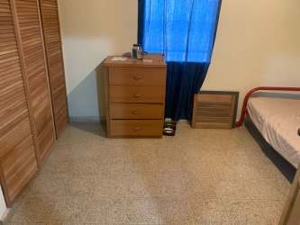Bedroom with double bed, closet, dresser, red sofa in Vista Alegre Arraiján Panama house