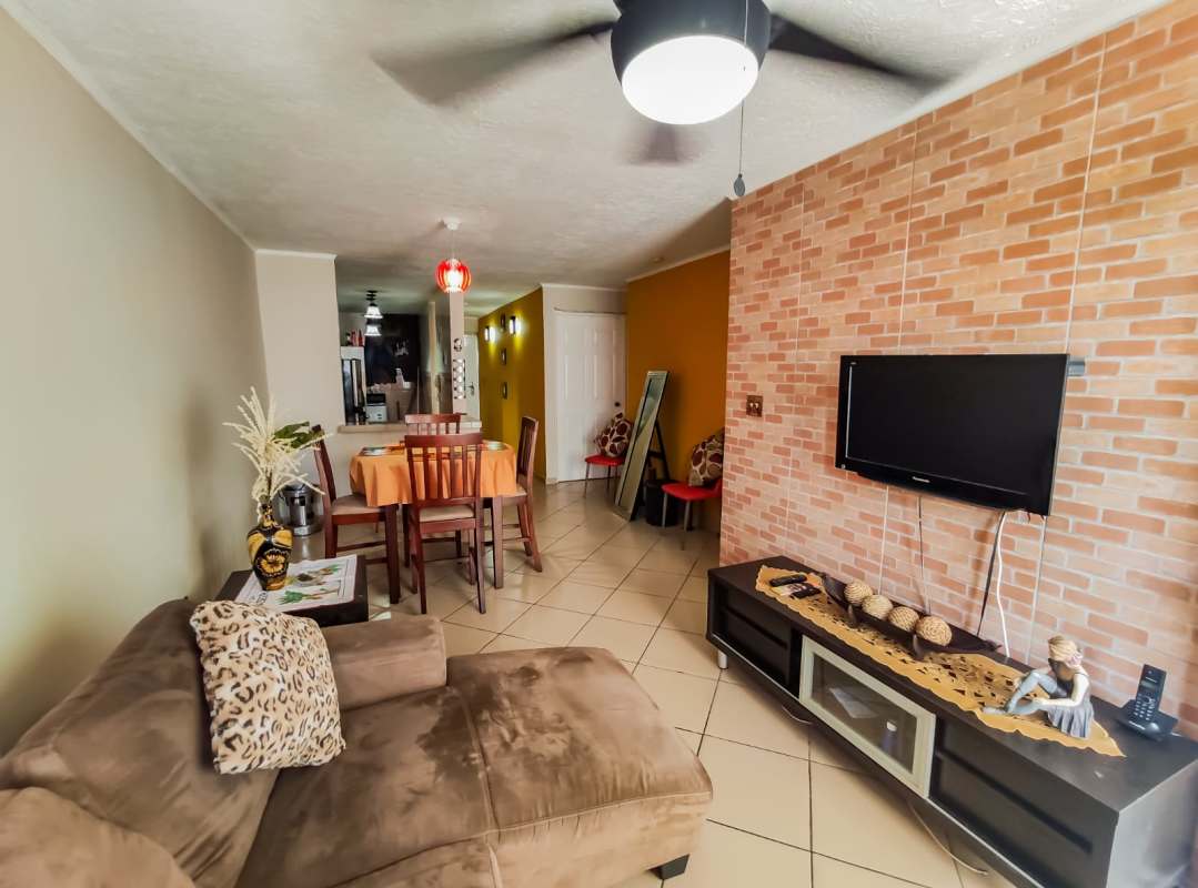 Galley kitchen with brown cabinets, granite counter, microwave shelf PH Pueblito Lindo Panama