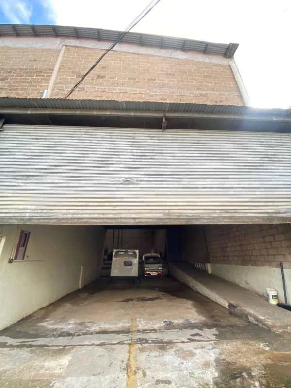 Covered garage style industrial warehouse entry with metal roof and truck parking Juan Díaz Panama