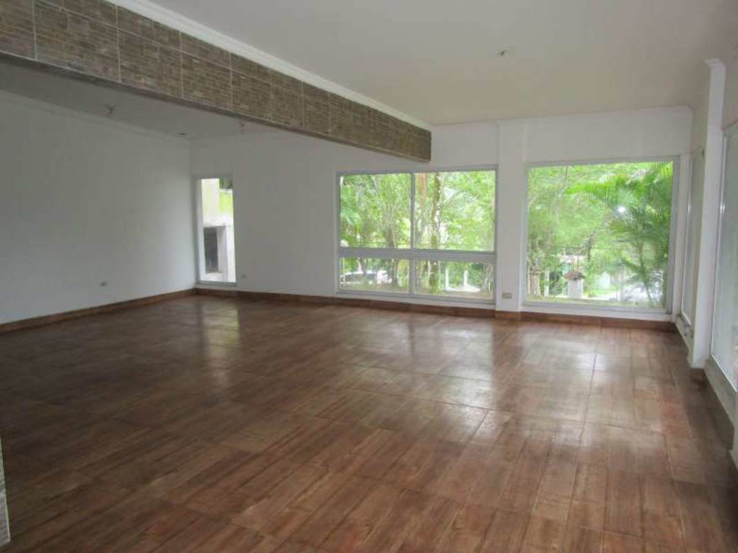 Large open living area with tile floor and windows in Las Cumbres lake house Panama