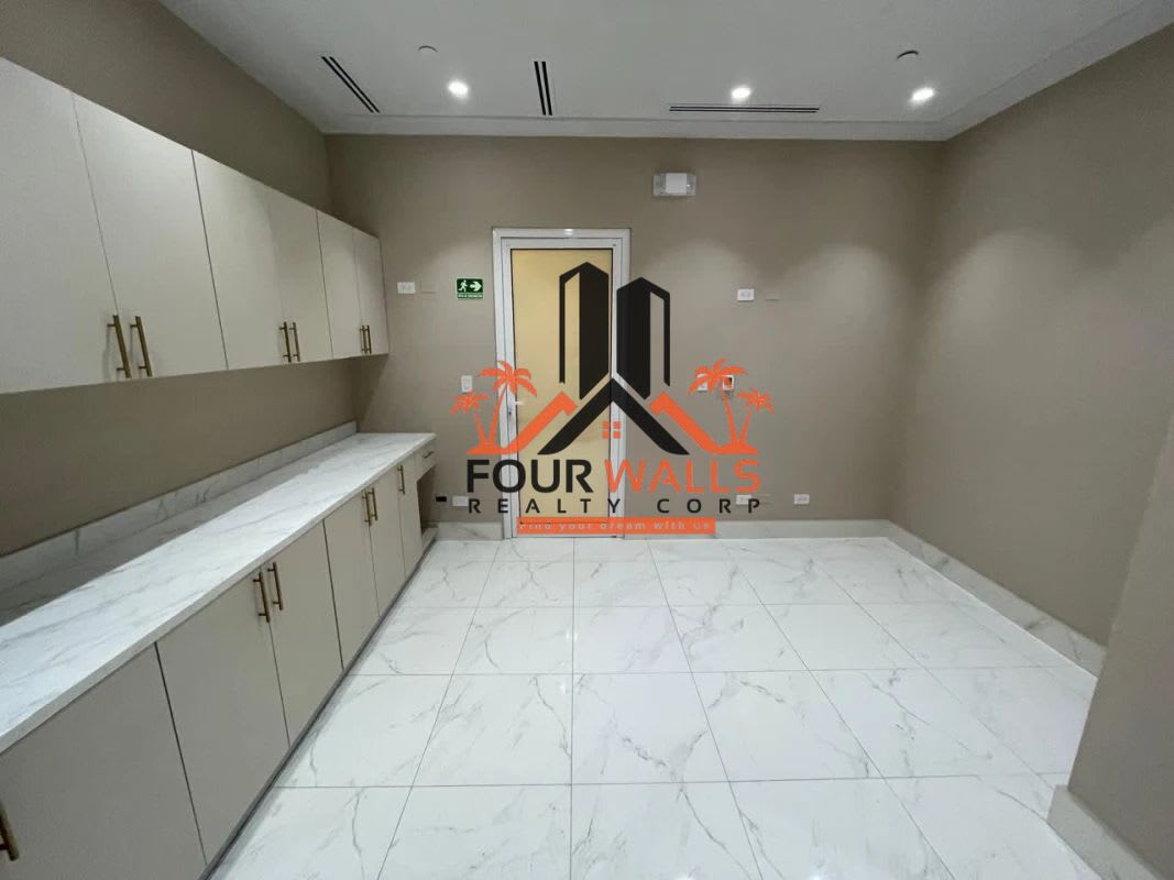 Compact kitchenette with marble counter, cabinets and neutral tones at Town Center Costa del Este Panama