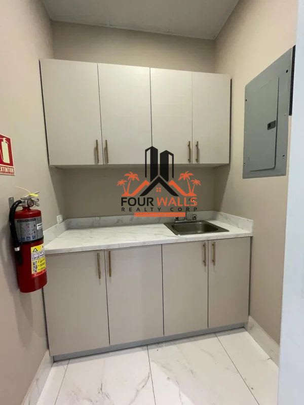 Minimalist kitchenette with beige cabinets, marble look counter Town Center Panama City