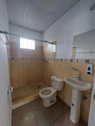 Bathroom with walk-in shower, tiled walls and pedestal sink in affordable Panama house for sale