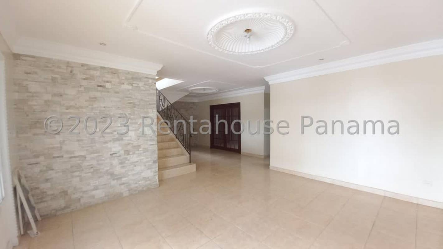Traditional entrance hallway with iron staircase and stone accent wall in duplex home Panama City