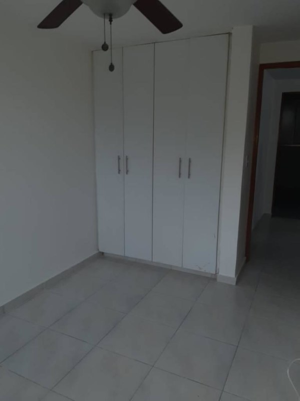 Living room with ceiling fan, large glass doors leading to enclosed balcony in PH Llano Bonito Panama