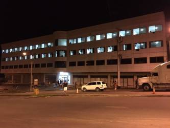 Night view three-story commercial building lit up Paso Canoas border Panama.