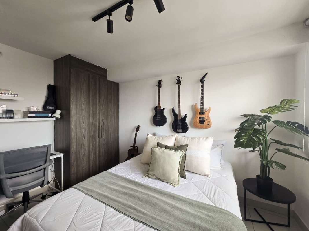 Bedroom featuring workspace and musical decor wall-mounted guitars PH Sky Point Carrasquilla Panama