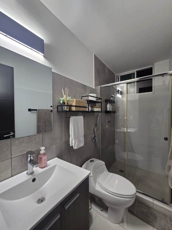 Minimalist modern bedroom with wall-mounted TV, AC, and dresser at PH Sky Point in Carrasquilla Panama