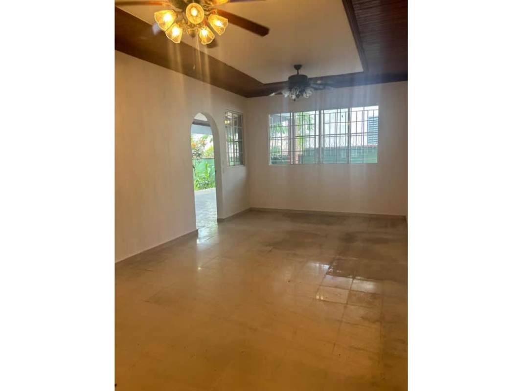 Bedroom space with wood floors, built-in wardrobe, large window with grille in Loma Alegre Panama City