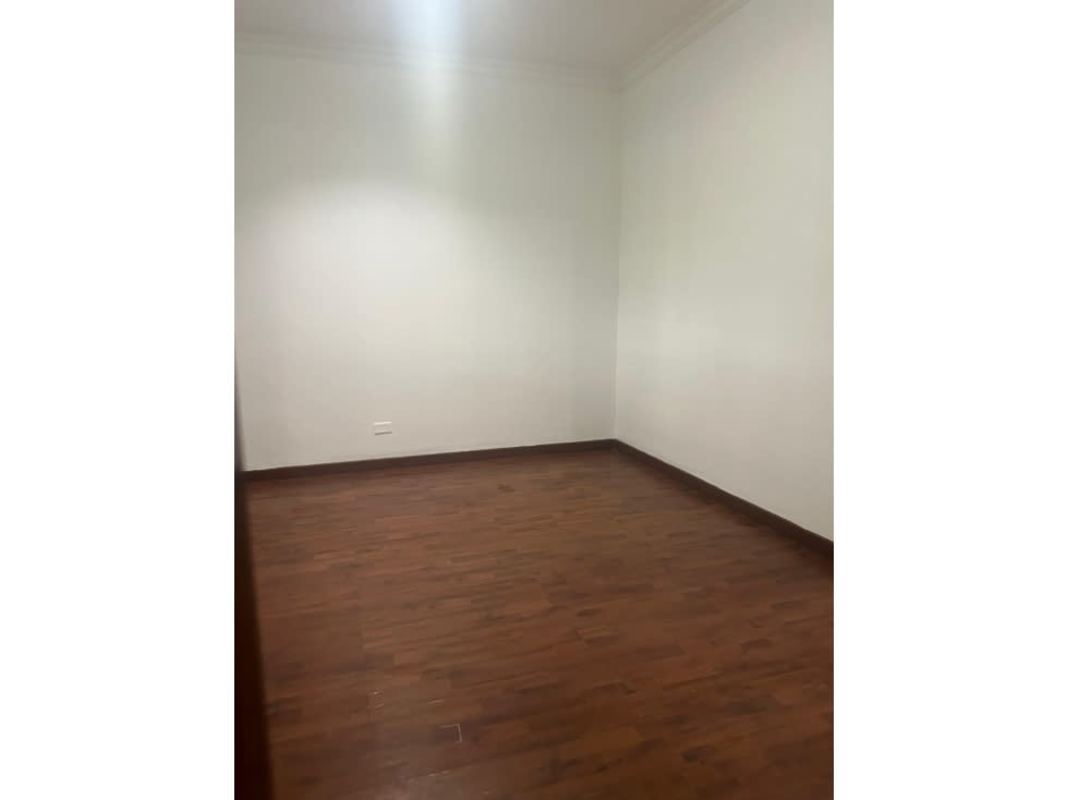 Empty bedroom with wooden flooring, security grille window, built-in closet in San Francisco Panama City
