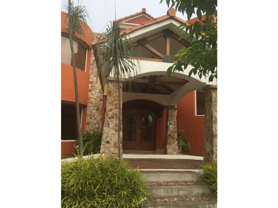Spacious entryway with wooden staircase, stone accent wall, double doors at luxury home Loma Alegre Panama City