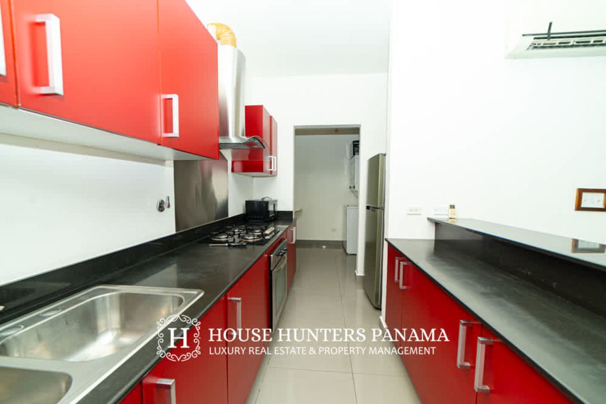 Modern kitchen with appliances and red cabinetry PH Quartier 74 San Francisco Panama