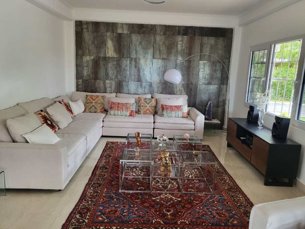Contemporary living area with sectional sofa, accent wall, large windows in Albrook Panama mansion