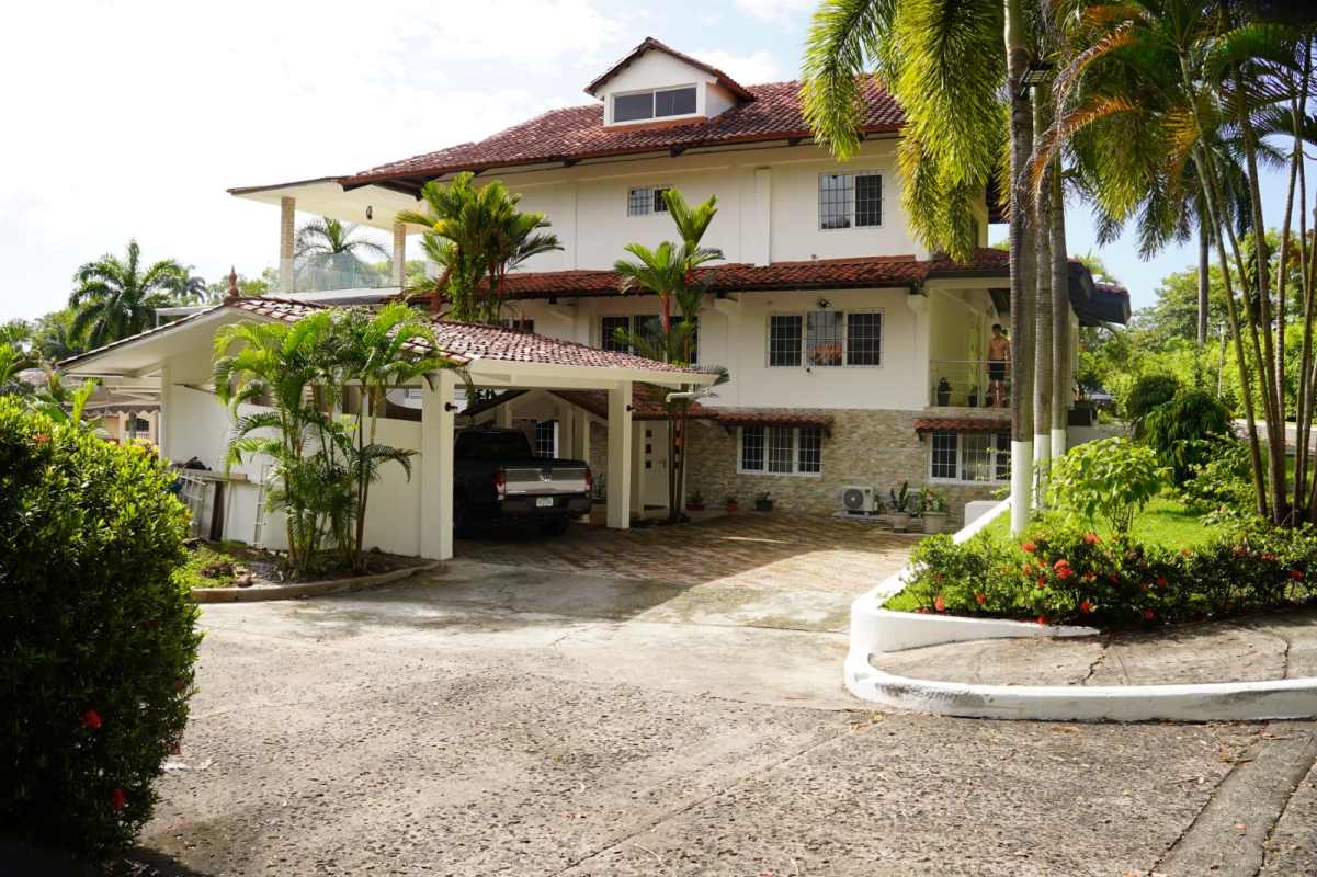 Mediterranean luxury mansion exterior with tiled roof, palm garden, driveway in Albrook Panama