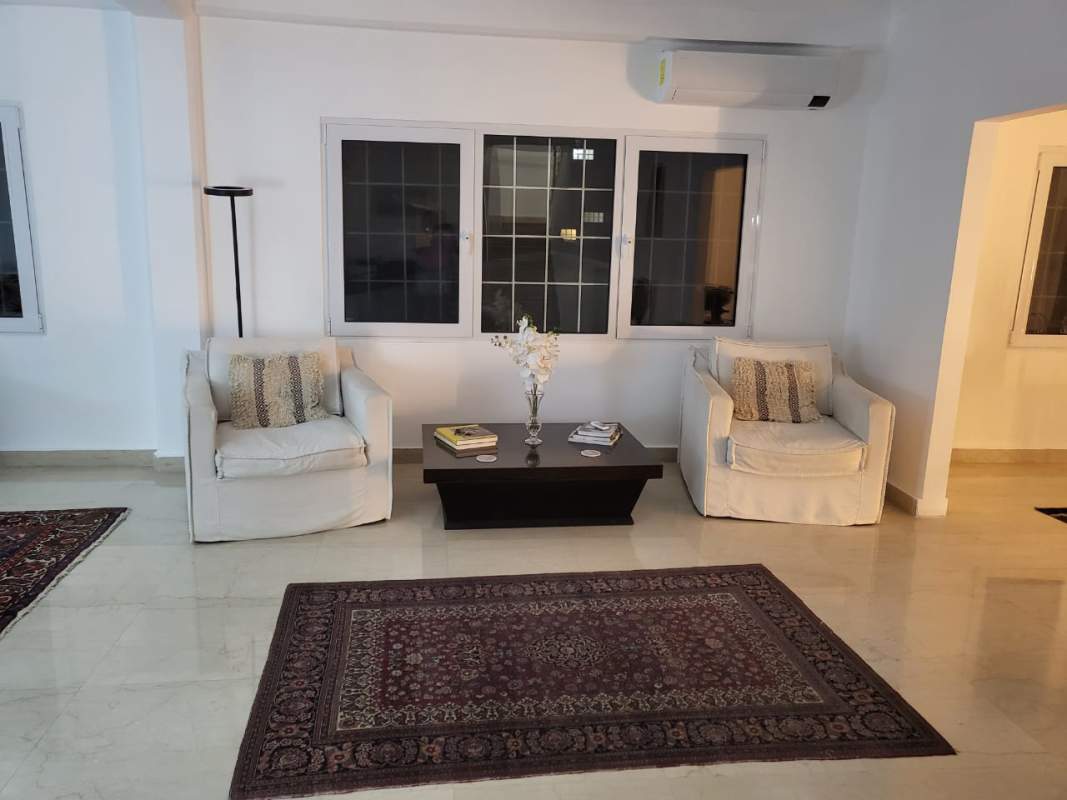 Minimalist living area with armchairs, grid windows, bright space in Albrook luxury mansion Panama