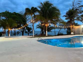Oceanfront pool with palm trees and decorative lights at Playa Toro Pedasi Panama