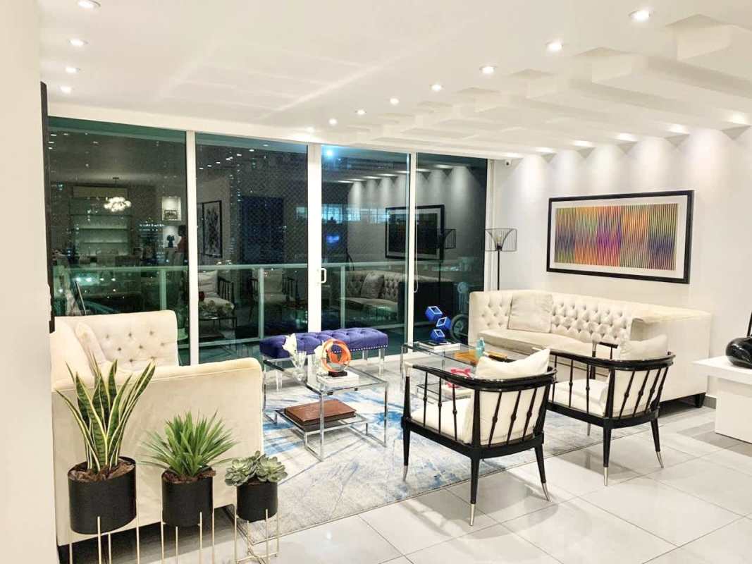 Modern glass dining table, abstract art, chandelier in elegant Punta Pacifica condo