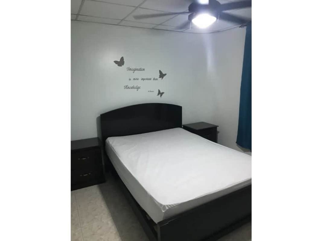 Utility laundry area with washer, utility sink, and shelf in apartment Betania Panama