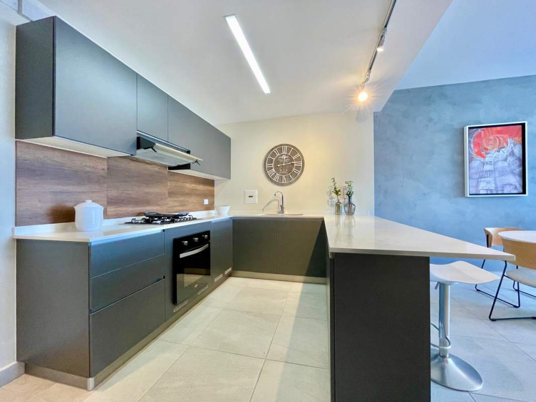 Modern kitchen with bar seating and wood accents PH Van Gogh Panama City