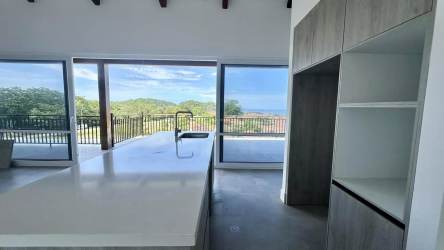 Modern kitchen with island, panoramic window, nature view at Blue Venao Panama