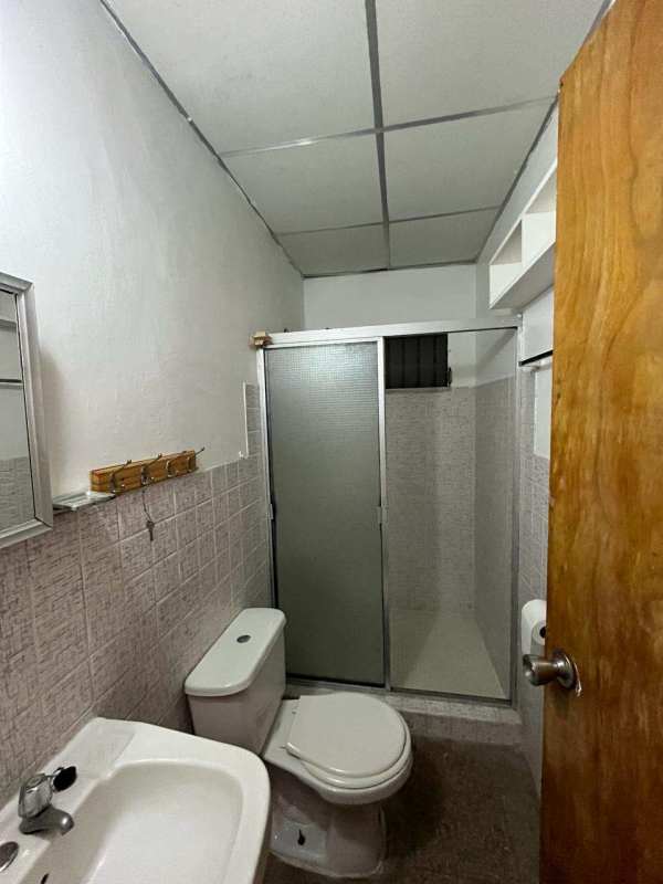 Small bathroom with glass shower, tile walls, mirror and sink in house for sale Panama City
