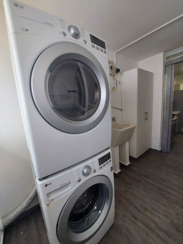 Laundry room equipped with washer, dryer, storage shelving and ventilation window at PH Balboa Bay Bella Vista Panama