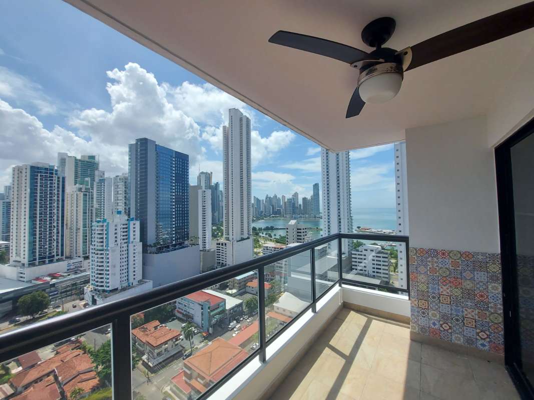 Large balcony with seating area overlooking ocean horizon and city skyline in PH Balboa Bay Panama City