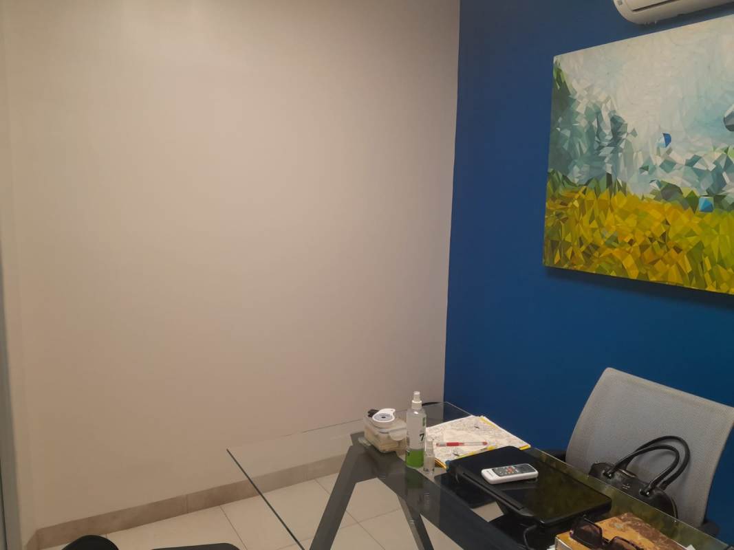 Furnished coworking office for rent with desk, seating, art, and blue accent wall in PH BICSA Tower Panama
