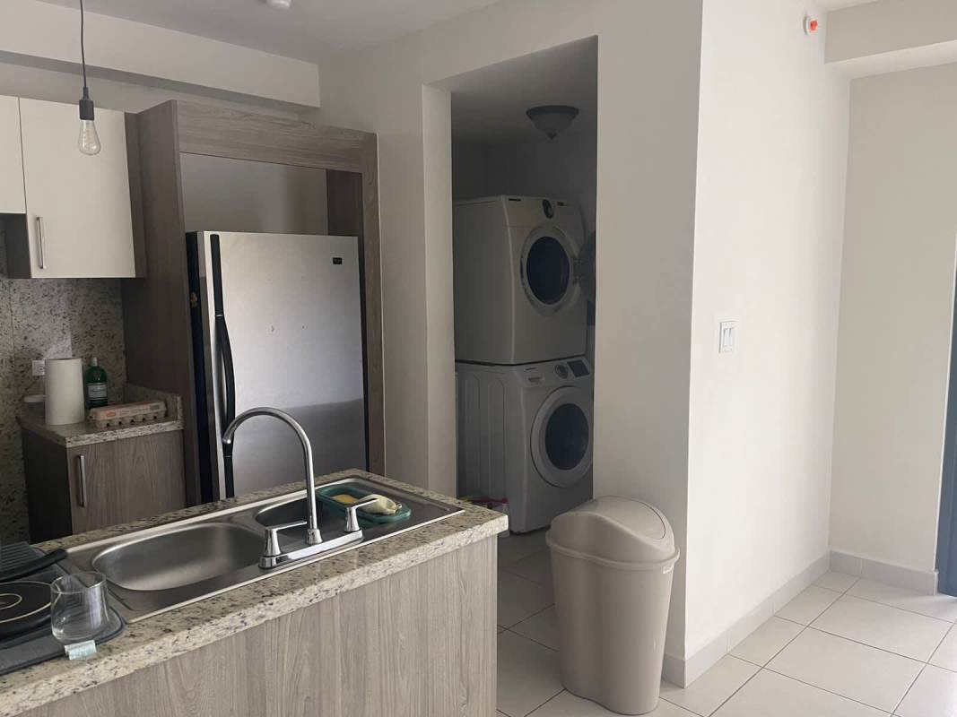 Bedroom with sliding glass door leading to balcony overlooking green forest in PH Embassy Village Clayton Panama