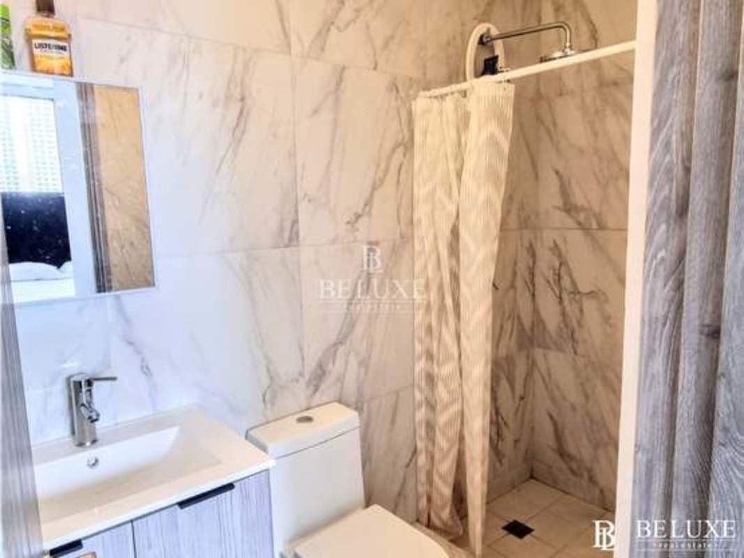 Modern minimalist bedroom with large window, blue headboard, city view in PH The Gray Obarrio Panama