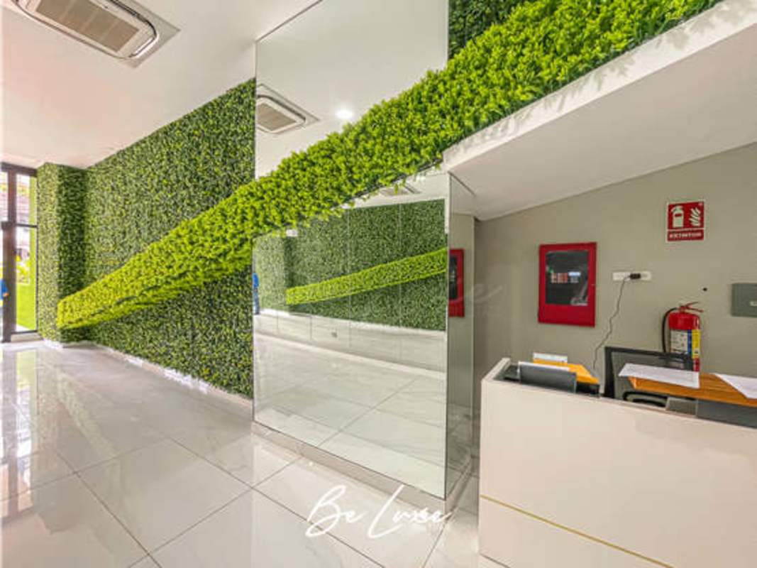 Indoor gym with machines, weights, mirror wall and city view in PH The Gray Panama