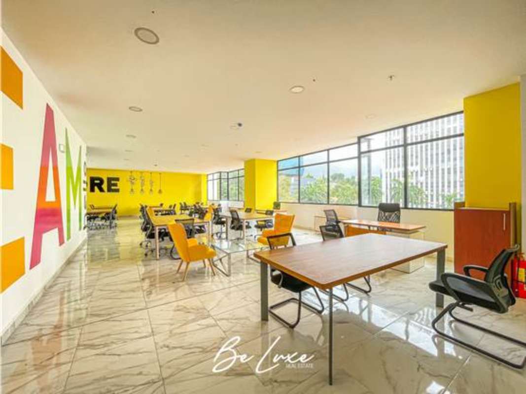 Bright modern open-plan office space, marble flooring, mural, city view at PH The Gray Panama