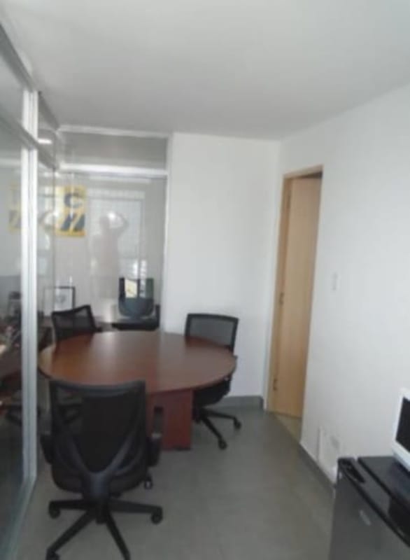 Meeting room with round table, glass wall, fridge and chairs in PH Los Colores de Bella Vista Panama City