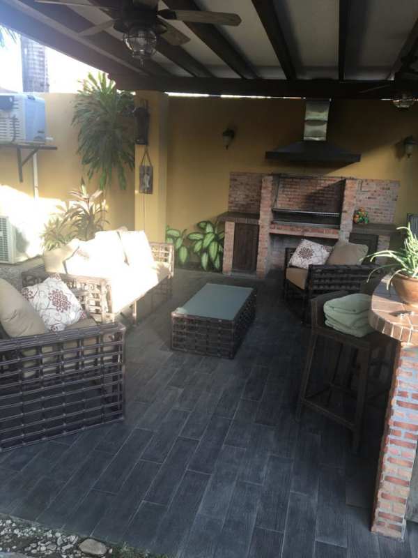 Modern living and dining area, sectional sofa, bar, red accents, garden view in Costa del Este