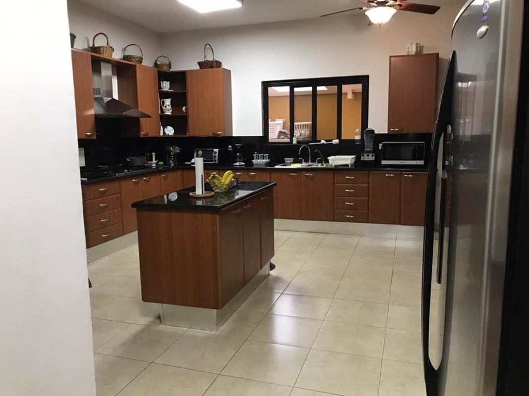 Open concept living room with sectional sofa, indoor bar, modern decor La Antigua