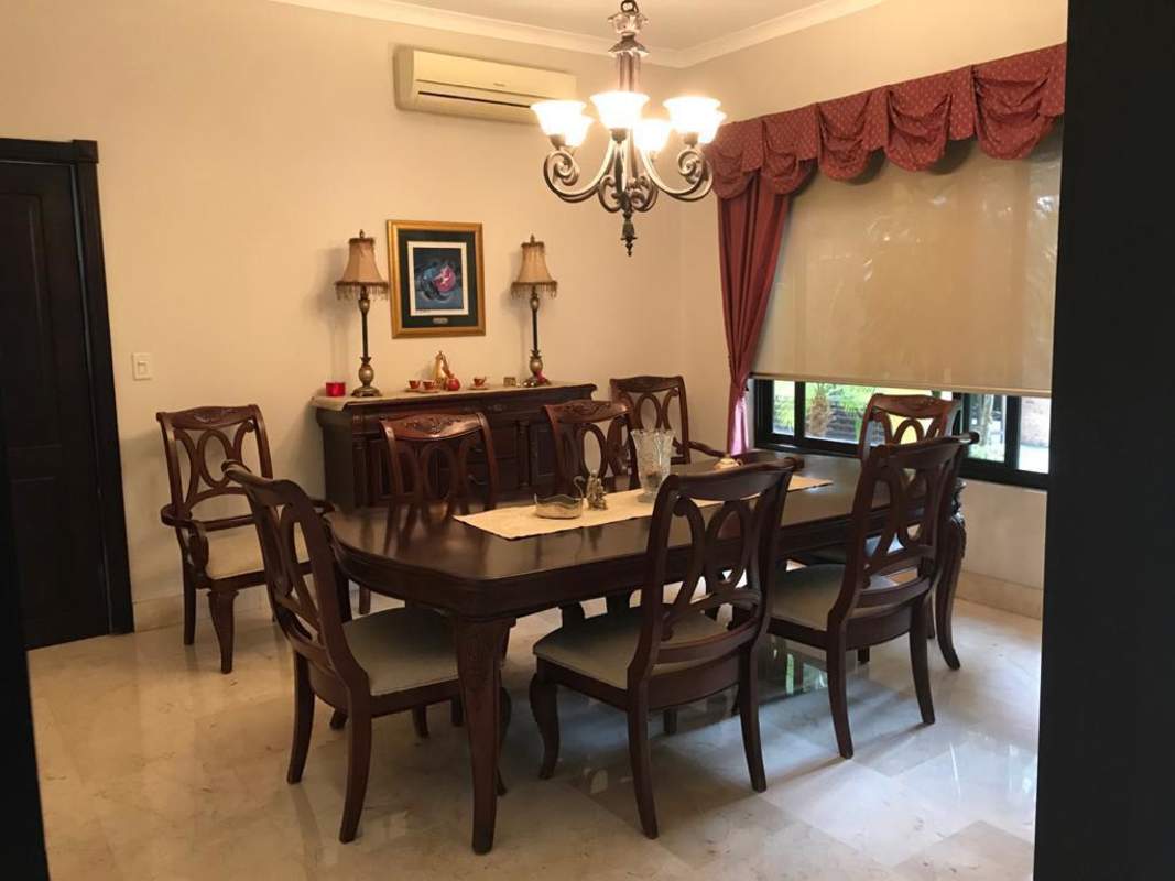 Mediterranean facade with terracotta roof, arched entry and lush landscaping at La Antigua Costa del Este