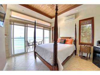 Elegant guest bedroom with large sliding glass oceanfront balcony at San Carlos Panama boutique hotel