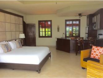 Studio suite interior with king bed kitchen island and tropical design in San Carlos Panama