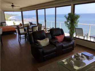 Bright living room with glass windows and Pacific ocean views at Ocean Pearl Hotel San Carlos Panama